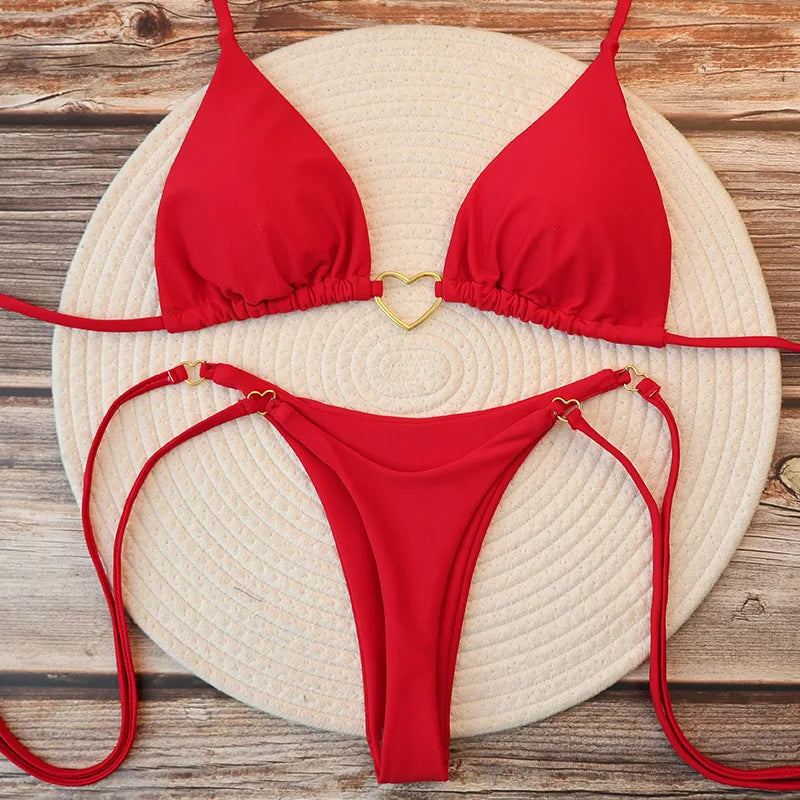 Biquíni vermelho feminino fio dental com coração dourado em flat lay, conjunto moda praia
