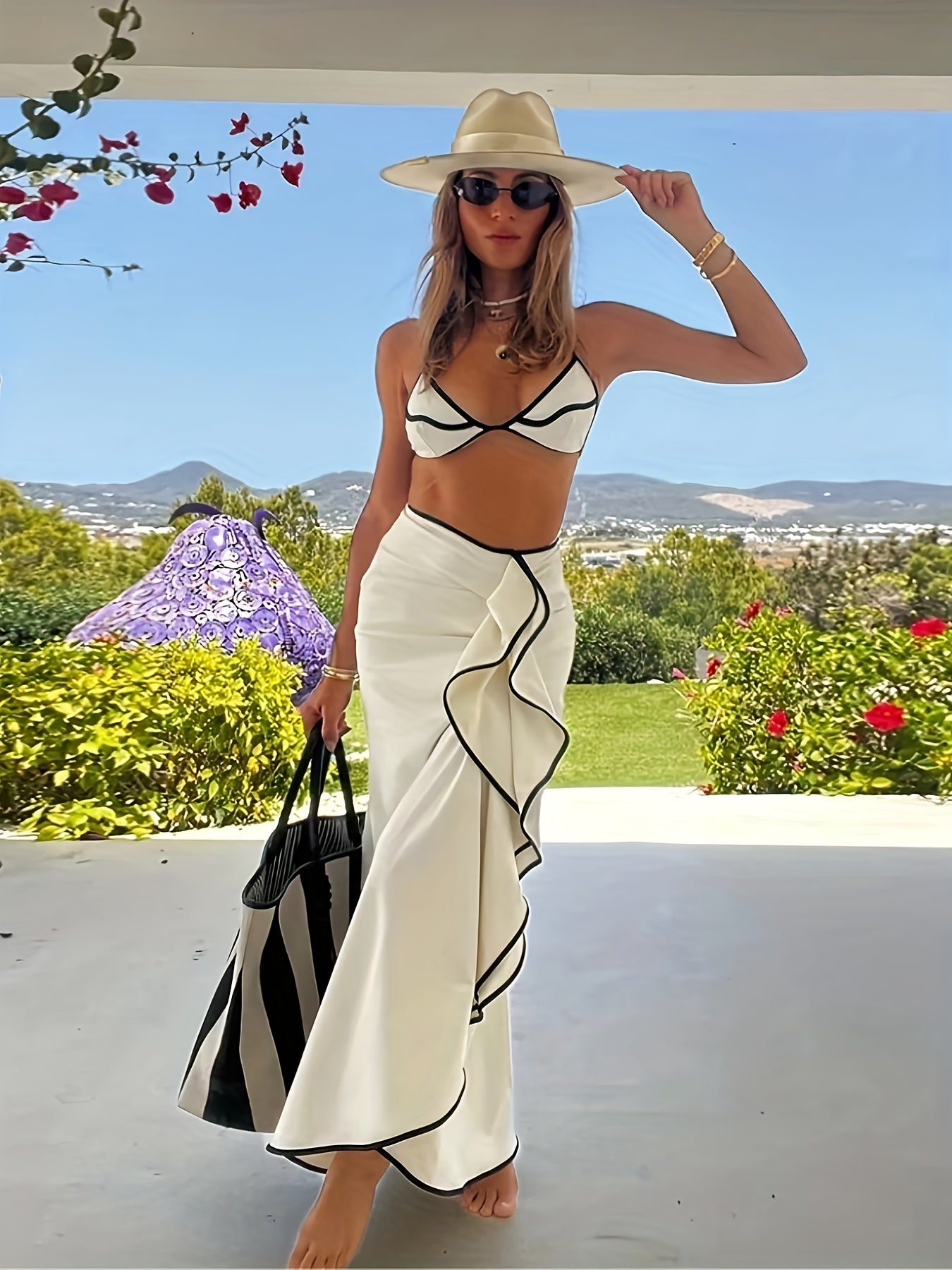 Mulher usando saída de praia bege com biquíni preto em ambiente ensolarado de verão