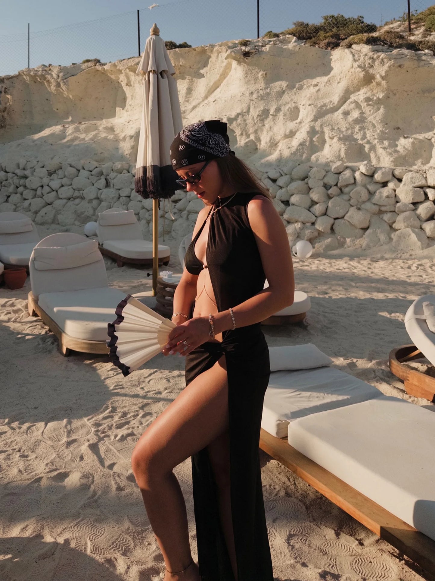 Mulher usando saída de praia preta com fenda, visual moderno e sensual para beach club e piscina